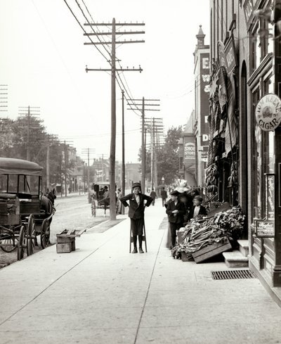 A boy with stilts standing in front of the F.J. Voepel Market at 4874 Easton Avenue, at the southeast corner of Easton and Euclid. Easton was later known as Dr. Martin Luther King Drive by Unknown